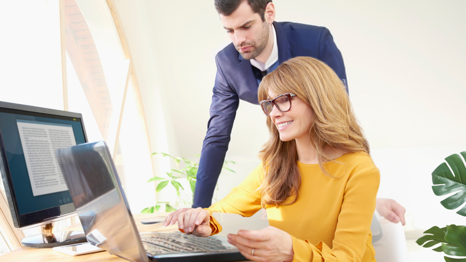 Passende Assistenz finden - Sekretärin mit Geschäftsführer am Arbeitsplatz